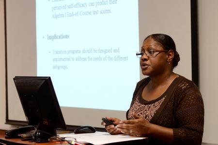 LaJuana Hamer, graduate studying for a doctor of education in curriculum and supervision degree, presents her research on the effect of relocation on students' academic performance during the Scholarship Symposium. - Photo by Jacob Moore