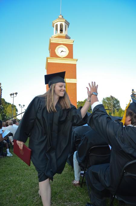 Rachel Taylor, elementary education graduate, high-fives Cooper Rawls, physical education and health graduate, after receiving her diploma during spring graduation. - Photo by Zac Calvert