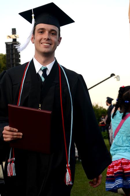 Andy Seaton, Christian studies graduate, joyfully walks back to his seat after receiving his diploma during  spring graduation.  - Photo by Anne Richoux