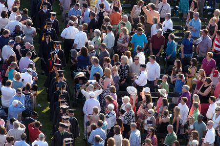 Graduates make their way through a large crowd of friends and family during the processional for spring graduation.  - Photo by Kristi McMurry Woody