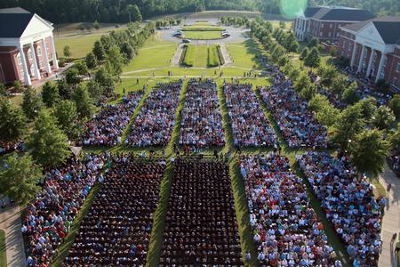 614 graduates gather with friends and family on the great lawn for spring graduation. - Photo by Kristi McMurry Woody