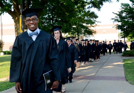 Skyler Vaden, sports management graduate, walks to his seat during the processional at spring graduation.  - Photo by Ebbie Davis