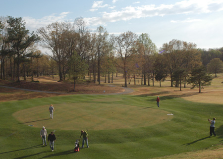 The men's golf team converges on the hole during a practice round. - Photo by Jonathan Blair
