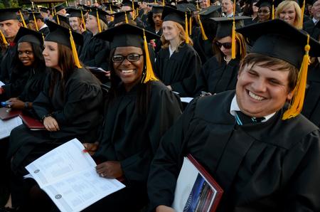 Bri Rauls (center), athletic training graduate, laughs with fellow graduates at spring graduation. Rauls is the first of her family to graduate from a university. - Photo by Ebbie Davis