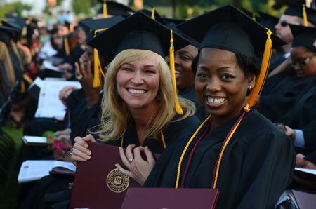 Jessica Emerson and Benita Hale, organizational leadership graduates, pose together after receiving their diplomas at spring graduation. - Photo by Jacob Moore
