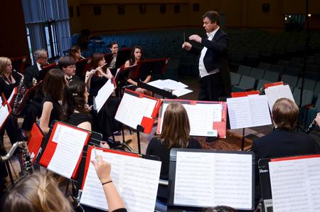 Michael Mann, visiting assistant professor of music, directs during a symphonic band concert.  - Photo by Ebbie Davis