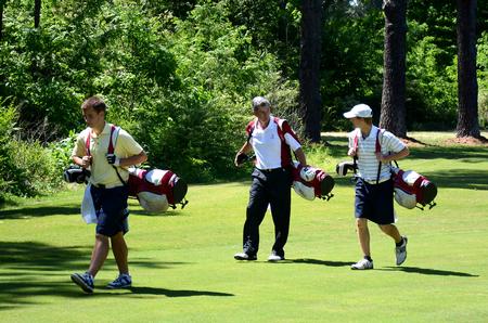 Andy Rushing (middle), head golf coach, walks across the golf course while coaching his players.  - Photo by Zac Calvert