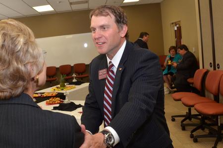 Jan Bould, assistant to the president for constituent relations, greets John McDearman, III, executive vice president of Wilson Bank and Trust, at the beginning of the Hendersonville dedication ceremony. - Photo by Morris Abernathy