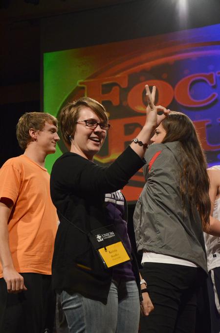 Krista Bradley, senior teaching English as a second language major, gives her focus group the "OK" sign before participating in a rock-paper-scissors tournament between focus leaders during the annual SAC game show. - Photo by Zac Calvert