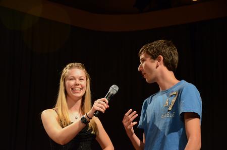 Megan Miller, senior social work major, holds the microphone for Michael Avery, freshman christian studies major, as he participates in the annual SAC game show. - Photo by Zac Calvert
