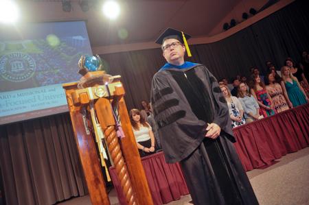Gavin Richardson, faculty member of the year and bearer of the mace,  watches as faculty members proceed in to the George M. Savage Memorial Chapel for Fall Convocation. - Photo by Morris Abernathy