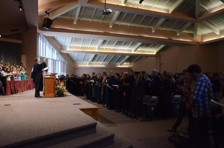 Chris Mathews, associate professor of music and department chair, leads the congregation of students, faculty and staff in singing "Joyful, Joyful We Adore Thee" during Fall Convocation. - Photo by Zac Calvert
