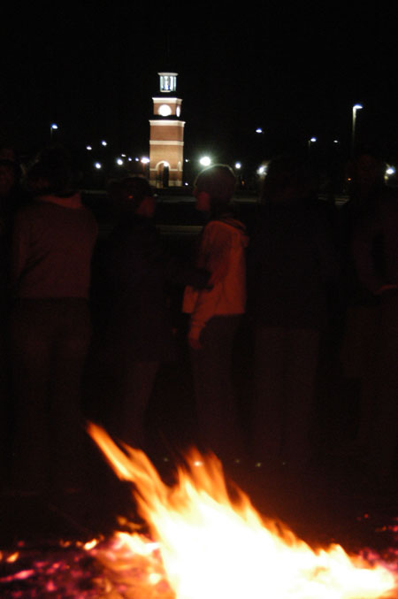 Students warm themselves at the Homecoming bonfire. - Photo by Lindsay Stavish