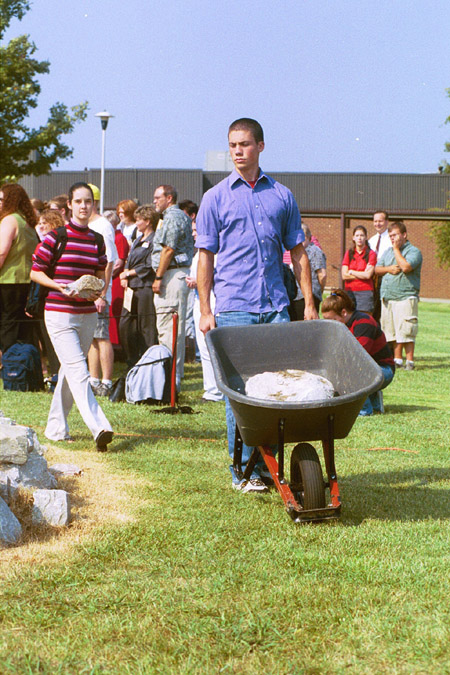 Sophomore Christian Studies major John Reed helps move a larger stone at the September 11 Service of Remembrance and Response. - Photo by Jim Veneman