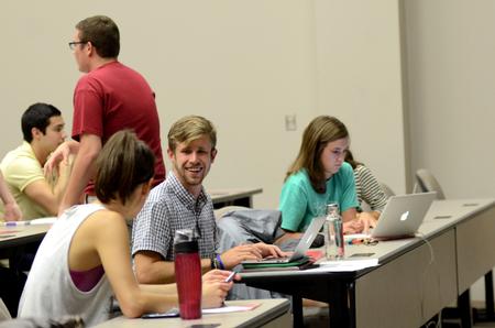 Kirby Lewis (center), senior political science major, talks with other students while waiting for Student Senate to begin in Harvey Auditorium.  - Photo by Anne Richoux