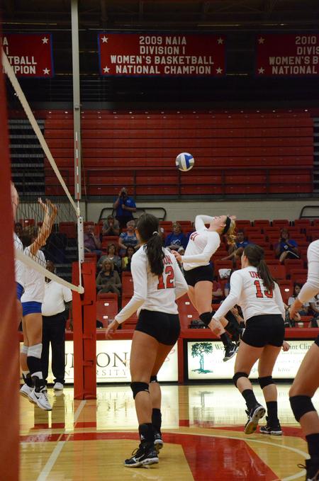 Savannah Hughes, sophomore biology major, leaps up to spike the ball during a game against University of Alabama-Huntsville. - Photo by Zac Calvert