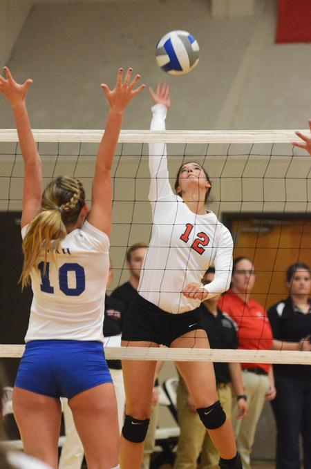 Abbey Wainwright, sophomore nursing major, spikes the ball as a player from University of Alabama-Huntsville tries to block it.   - Photo by Zac Calvert