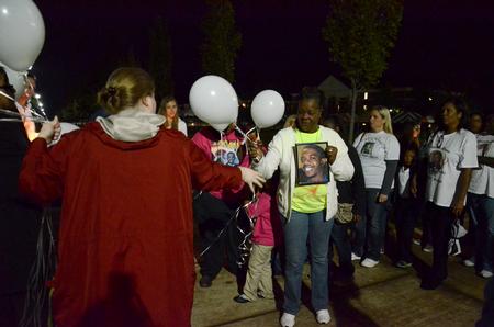 Homicide-loss survivor Gladys Turner receives a white balloon from a volunteer at the fifth annual Remember Me Commemorative Walk. The balloons were released in honor of lost loved ones. - Photo by Jacob Moore