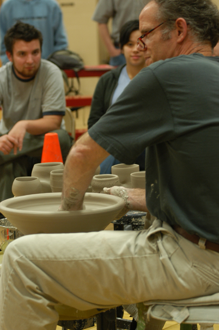 Art students watch closely as artist Chris Staley throws a pot during a ceramics workshop. - Photo by Jonathan Blair