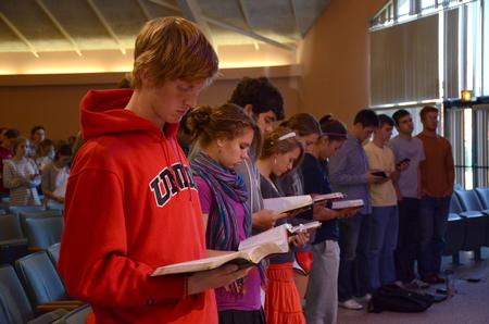 Students follow along as Larry York, pastor of Crossroads Baptist Church in Woodlands, Texas, reads the Scriptural account of Jesus healing the paralytic, found in Luke 5. - Photo by Jacob Moore