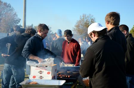Chris Hawks (left), junior accounting major, grills hamburgers and hotdogs for the pre-game tailgate celebrating Senior Night for the soccer teams.  - Photo by Anne Richoux