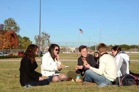 Elizabeth Oakes, Rachel Robbins, Peter Riggs, Caisie Jordan and Will Burke chat and laugh together during the pre-game tailgate celebrating Senior Night for the soccer teams. - Photo by Anne Richoux