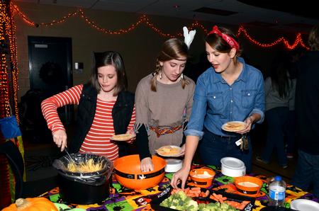 Kyleigh Carter, junior social work major, Laura Kay Richardson, junior elementary education major, and Mollie Tranum, junior psychology major, enjoy free snacks offered during Costume Coffee House. - Photo by Anne Richoux