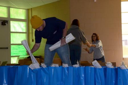Matt Moore, junior Christian studies major, puts Christmas supplies into gift bags while volunteering for The Salvation Army during Campus and Community Day. - Photo by Anne Richoux