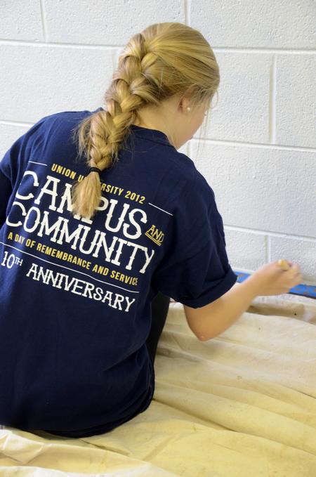 McKenzie Dorris, junior mathematics major, paints the trim in the youth room at Cornerstone Baptist Church. Dorris was joined by her LIFE group to work in the tenth annual Campus and Community Day.  - Photo by Ebbie Davis