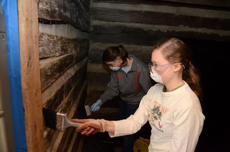 Patricia Dawson, senior history major, whitewashes the walls of a historic cabin at Parker's Crossroads Battlefield with Gracie Wise, junior English major, during Union's tenth annual Campus and Community Day. - Photo by Jacob Moore