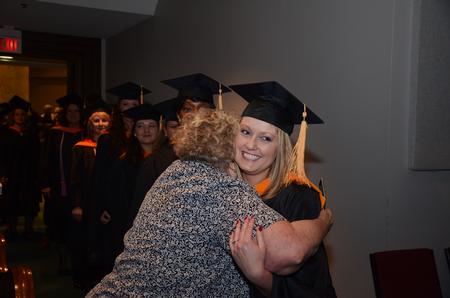 Emily Flowers, master of science in nursing, gives her grandmother, Judy Wallace, a quick hug during the graduate procession into the sanctuary at West Jackson Baptist Church during Fall Commencement. - Photo by Zac Calvert