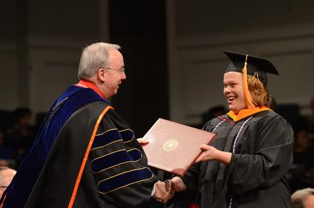 Kimberly Stanley, master of science in nursing, smiles as David S. Dockery, president of the university, presents her with her diploma during Fall Commencement. - Photo by Zac Calvert