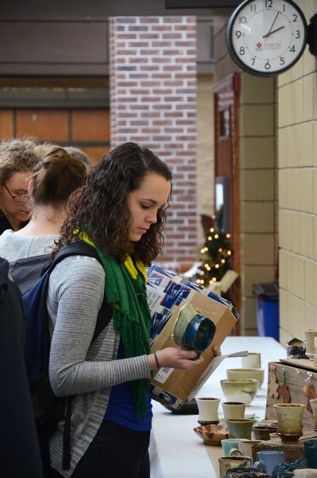 Rebecca Blevins, junior biology major, admires a cup on sale in the Student Union Building during the annual Christmas pottery sale. - Photo by Zac Calvert