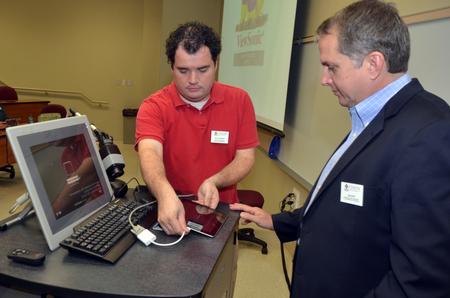 Willie George, PC support specialist, and Jim Avery, associate vice president for information technology, set up for a presentation to faculty members at the start of the Fall semester.  - Photo by Morris Abernathy