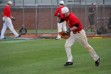 John Reed, junior sociology major, picks up his glove and jogs to the outfield to field fly balls during practice.
 - Photo by Matt McDaniel