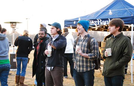 Alex Charles, junior engineering major, Taylor Hare, junior English major, Evan Estes, sophomore advertising major, and Dylan Pelley, sophomore Christian studies major, enjoy free hot chocolate and popcorn during the Homecoming Winter Wonderland.  - Photo by Anne Richoux