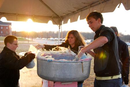 Stephanie Kesner, gifts processing coordinator, and Haaken Magnuson, sophomore biology major, give out free cotton candy during Homecoming Winter Wonderland. - Photo by Anne Richoux