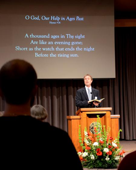 Chris Mathews, associate professor of music and department chair, leads in singing <em>O God, Our Help in Ages Past</em> during Homecoming chapel. - Photo by Olivia Wallace