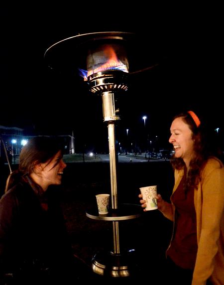 Anne Richoux, junior social work major, and Kristen Reed, junior nursing major, chat and enjoy hot chocolate near a heater at the Homecoming Winter Wonderland. - Photo by Olivia Wallace