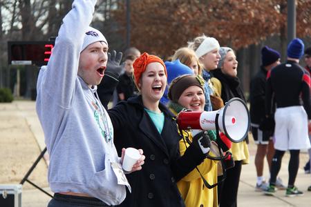 Jordan Wilson, senior accounting major, Shelly Ezell, senior elementary education major, and Kelly Rawls, junior elementary education major, cheer on runners as they cross the finish line of the Chi Omega 5K during Homecoming weekend. - Photo by Matt McDaniel