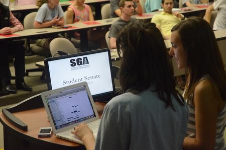 Anna Goodman, freshman broadcast journalism major, and Savannah Hari, junior sports medicine major, take role at the Senate meeting to make sure the representatives from the organizations are in attendance.
 - Photo by Matt McDaniel