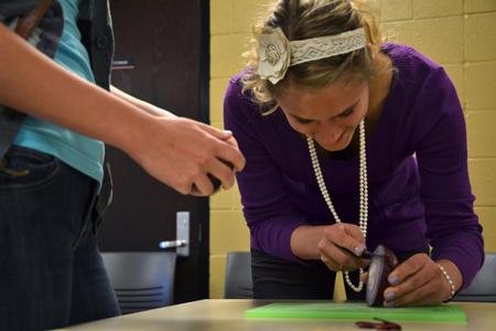 Morgan Kroeger, junior accounting major, dices a red onion for the southwestern black bean salad recipe during Cooking with Class, a residence life event. - Photo by Olivia Wallace