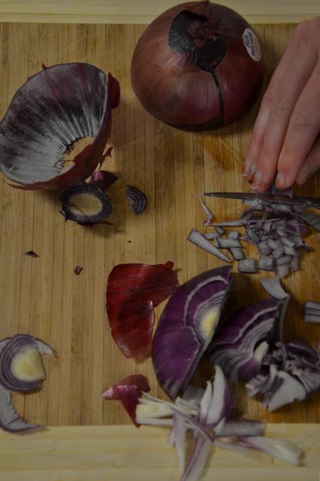 Kaitlyn Pindak, sophomore music education major, dices a red onion for the southwestern black bean salad recipe during Cooking with Class.  - Photo by Olivia Wallace