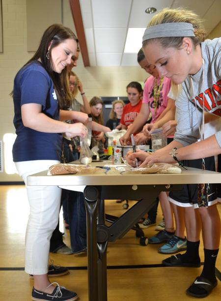 The ladies of the women's quads prepare a bag of dry brownie ingredients as a treat to take home as part of the residence life Cooking with Class event.  - Photo by Olivia Wallace