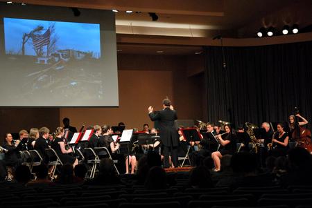Michael Mann, assistant professor of music, conducts the symphonic band as they play a tribute to the Joplin, Missouri tornado during their Spring concert. - Photo by Anne Richoux