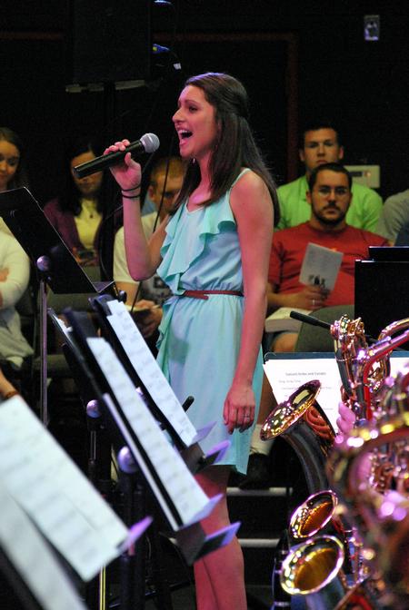 Melanie Arias, junior social work major, sings as the jazz band performs in concert in the W.D. Powell Theatre. - Photo by Anne Richoux