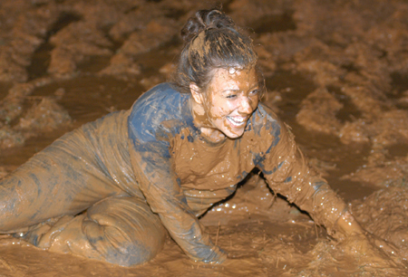 Junior Allison Seaman enjoys a mud bath during the Young Alum's Midnight Mudness. - Photo by Jonathan Blair
