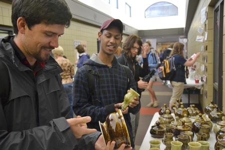 Mark Waite, senior biblical studies major, and Tommy Woods, sophomore art major, check out the pottery for sale at the annual Mother's Day pottery sale, hosted by the Potter's Guild. - Photo by Olivia Wallace