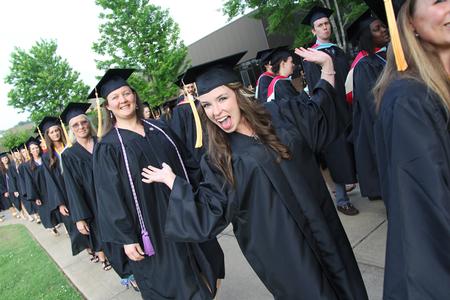 Lauren Ritchie, graduate of nursing, happily makes her way to the Great Lawn at the beginning of Spring Graduation. - Photo by Matt McDaniel