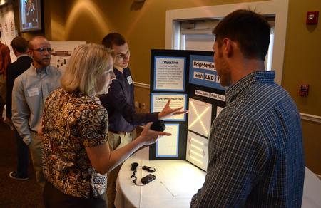 From left, engineering students Todd Jones, Dylan Baker and Kian Jost share their presentation titled "Brightening the Future with LED Technology" with Jeanette Russ, professor of engineering and department chair. - Photo by Jacob Moore